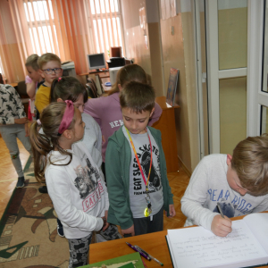 Uczniowie wpisują się do Kroniki Biblioteki