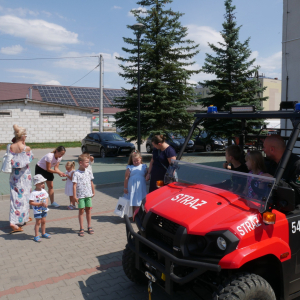 Pojazd strażacki i uczestnicy spotkania