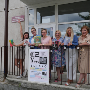 Sześć kobiet pozuje do zdjęcia przed biblioteką