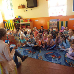 Pani bibliotekarka pokazuje dzieciom książeczkę