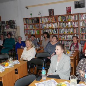 Uczestnicy spotkania siedzą przy stoliczkach