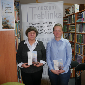 Dwie kobiety pozują do zdjęcia, w tle rollup Muzeum Treblinka