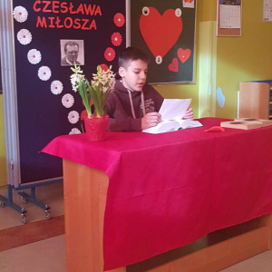 Uczeń siedzi przy biurku i czyta