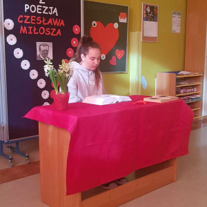 Uczennica siedzi przy biurku i czyta