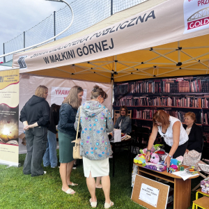 Uczestnicy Dożynek Gminnych przy stoisku promocyjnym biblioteki