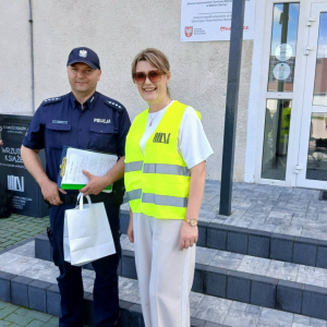 Pan dzielnicowy i pani dyrektor biblioteki pozują do zdjęcia