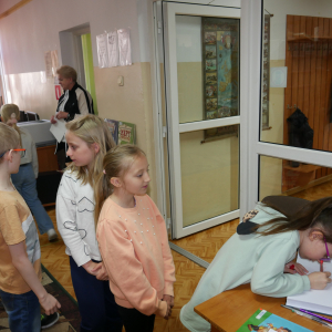 Uczniowie wpisują się do Kroniki Biblioteki