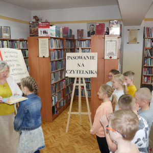 Pani dyrektor pasuje uczniów na Czytelnika 