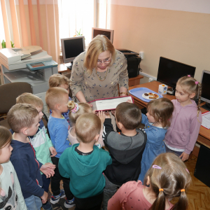 Pani bibliotekarka pokazuje książkę przedszkolakom