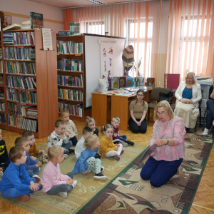 Pani bibliotekarka pokazuje książeczki  przedszkolakom